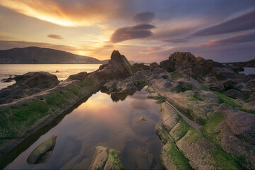 Warm sunset in Kantarepe cove, in Algorta, with a sky of intense colors and the sea water...