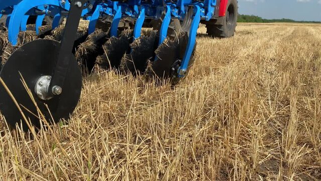 Close-up of a large modern plow blue color or disc harrow for cultivating the land.