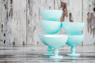 Group of turquoise ice cream bowls on white wooden background with copy space.