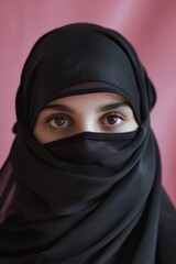 Naklejka premium A woman wearing a black hijab looks directly at the camera