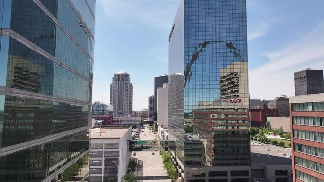 Vertical drone footage of downtown Saint Louis, Missouri with buildings in the arch showing in window reflections on a bright and sunny summer day.