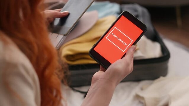 Sad unrecognizable woman at home angry holding phone cancel flight message delay airplane airport cancelation trip airplane female girl throw tickets passport problem trip travel journey vacation