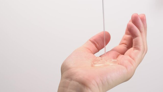 Cleansing shampoo or shower gel pouring into woman palm.  Haircare, therapy, hygiene concept.