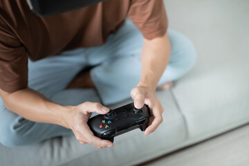 Young Asian man gamer controller video console playing holding hobby playful Online Video Game enjoyment eSport Cyber Games Internet.