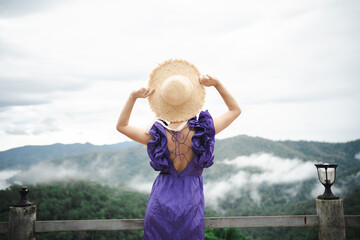 Carefree happy woman in morning of nature cliff mountain. Woman travel tourist alone morning...