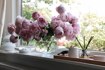 Beautiful pink peonies in vase on window sill. Interior design