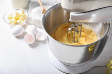 Making dough in bowl of stand mixer on white table, closeup. Space for text