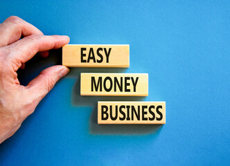 Easy money business symbol. Concept words Easy money business on beautiful wooden blocks. Beautiful blue table blue background. Businessman hand. Easy money business concept. Copy space.