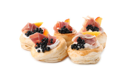 Delicious puff pastry with cream cheese, ham, black caviar and peach isolated on white