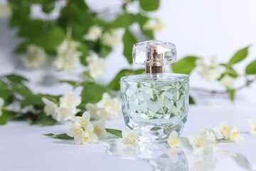 Aromatic perfume in bottle and beautiful jasmine flowers on white background