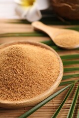 Coconut sugar and palm leaves on bamboo mat, closeup