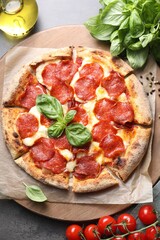 Tasty pepperoni pizza and ingredients on grey table, top view