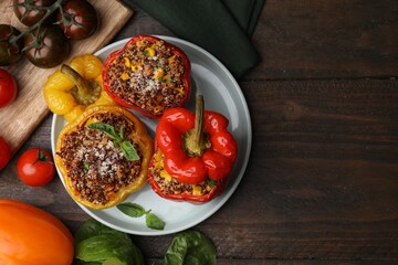 Quinoa stuffed peppers with corn and basil on wooden table, flat lay. Space for text