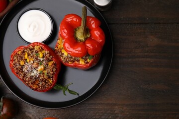 Quinoa stuffed peppers with corn on wooden table, flat lay. Space for text