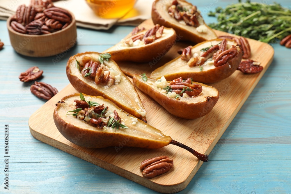Wall mural delicious baked pears with nuts, blue cheese, thyme and honey on light blue wooden table, closeup - Wall murals