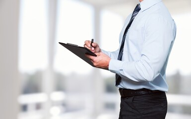 Hands of worker hold clipboard doing inspection