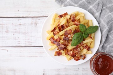 Delicious French fries with bacon, basil and ketchup on wooden rustic table, flat lay. Space for text