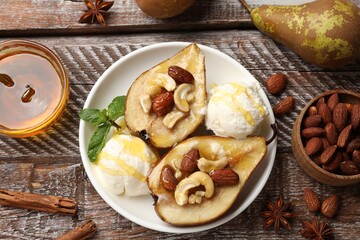 Delicious baked pears with nuts, ice cream, anise stars and honey on wooden rustic table, flat lay