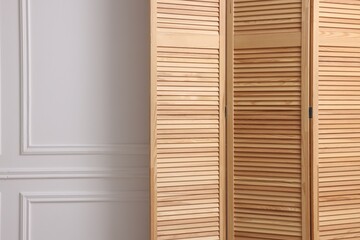 Folding screen near white wall indoors, space for text. Interior element