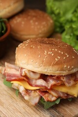 Delicious burger with bacon and cheese on table