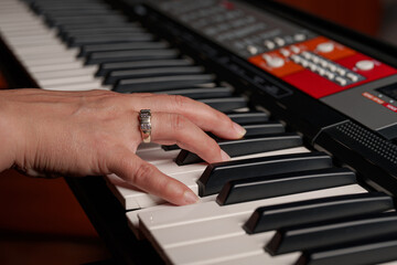 Female hand playing the electronic piano