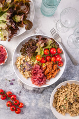 Ketogenic, paleo diet lunch bowl with grilled meat, cauliflower rice and mixed salad