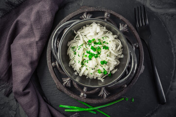 Homemade salad of grated white turnips with yogurt dressing and chives