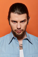 Stylish caucasian man with a beard wearing a trendy blue shirt.