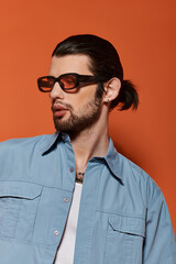 Caucasian man in trendy blue shirt sporting sunglasses.