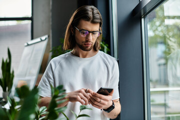 Fototapeta premium A caucasian businessman in a white shirt focused on his phone.