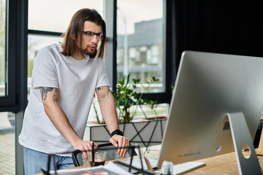 A caucasian businessman standing with a laptop in his office. - Powered by Adobe