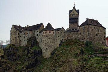 Naklejka premium Scenic landscape view medieval castle on the top of the hill. Loket Castle, Karlovy Vary region. Famous touristic place and romantic travel destination in the Czech Republic.UNESCO World Heritage Site