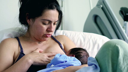 Mother breastfeeding newborn baby, showing a mix of discomfort and determination, highlighting the challenges and raw emotions of early motherhood in a hospital setting