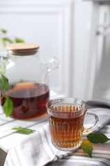 Tasty warm tea in cup on table, closeup