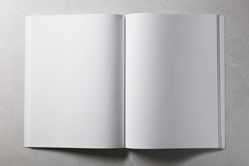 Open notebook with blank pages on grey textured background, top view. Mockup for design