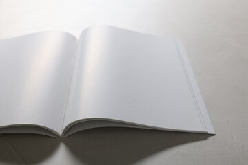 Open notebook with blank pages on grey textured table, closeup. Mockup for design