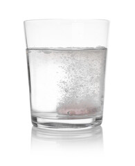 Effervescent pill dissolving in glass of water isolated on white