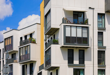 City view on a sunny day. Modern building and houses against the blue sky.