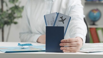 Travel agent holds out a passport with airline tickets