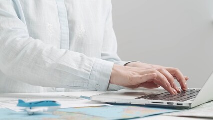 Travel agent typing on a laptop keyboard