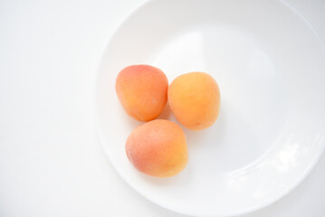 Yellow plums on a white plate. Fresh fruits.