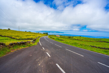 Tarmac road with the beautiful landscape surrounding the island of Pico in the Azores archipelago.