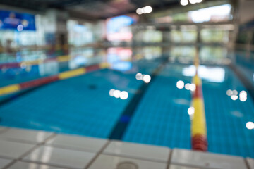 Defocused empty sport competition swimming pool with lanes, lens blur