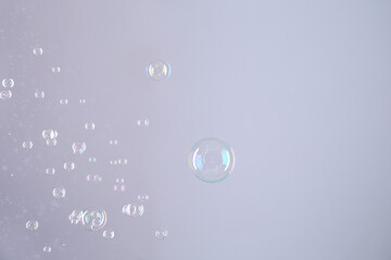 Beautiful transparent soap bubbles on grey background, space for text