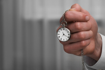 Man holding chain with elegant pocket watch, closeup. Space for text