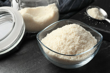 Fresh almond flour in bowl on dark table, closeup