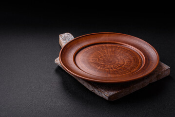 Empty ceramic round plate on dark textured concrete background