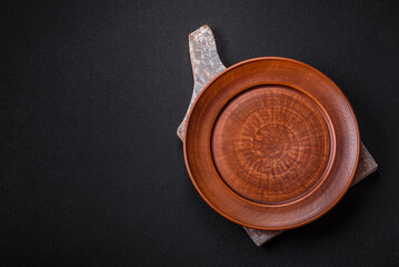 Empty ceramic round plate on dark textured concrete background