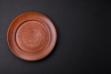 Empty ceramic round plate on dark textured concrete background