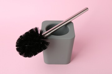 Toilet brush and holder on pink background